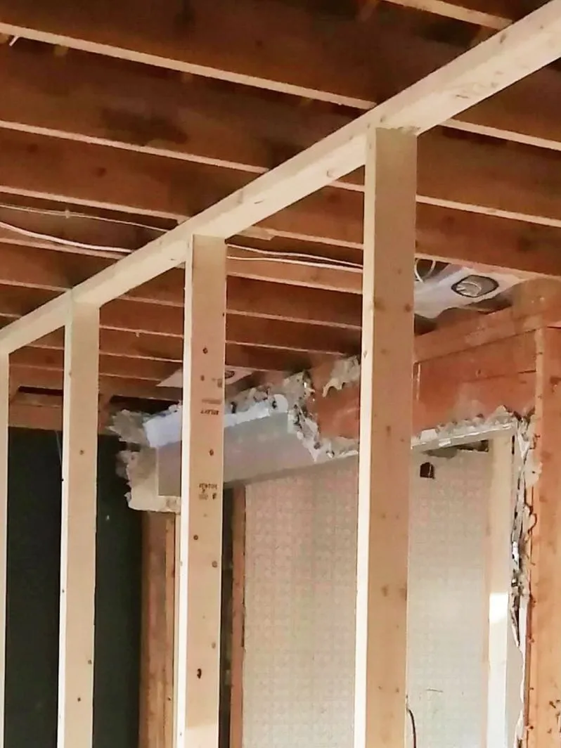 New wood framing going up in a room being renovated, with the ceiling joists open
