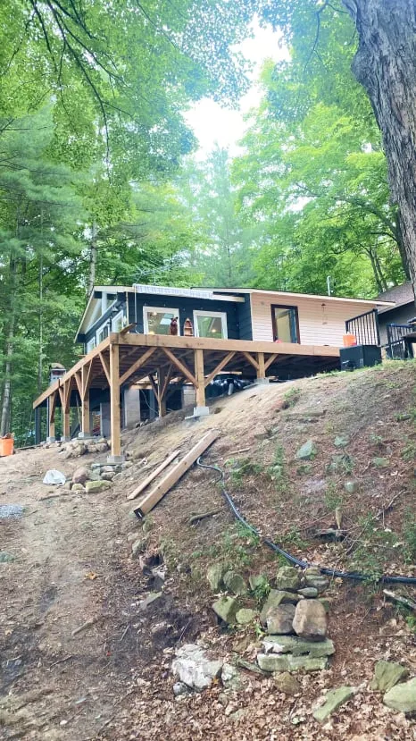 The cottage after the gazebo came down, with a new wood deck frame on braced posts.