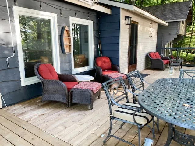 The new deck set with red-cushioned wicker chairs and a metal dining table