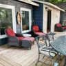 The new deck set with red-cushioned wicker chairs and a metal dining table