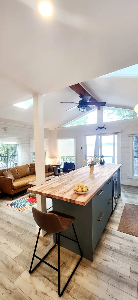 The wood-topped island with a bowl of lemons, looking toward the living area's tan sofa and sliding door.