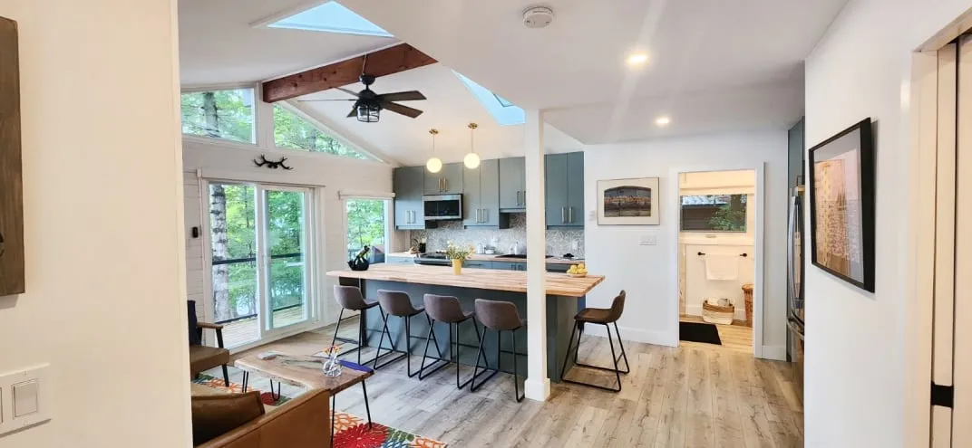 The open-plan kitchen and living room, with five stools at the island and a sliding door beyond.