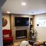 A cosy family room with a taupe shiplap fireplace wall and a mounted TV